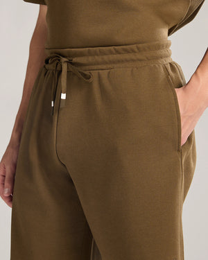Brown pants with a drawstring waist on a plain background