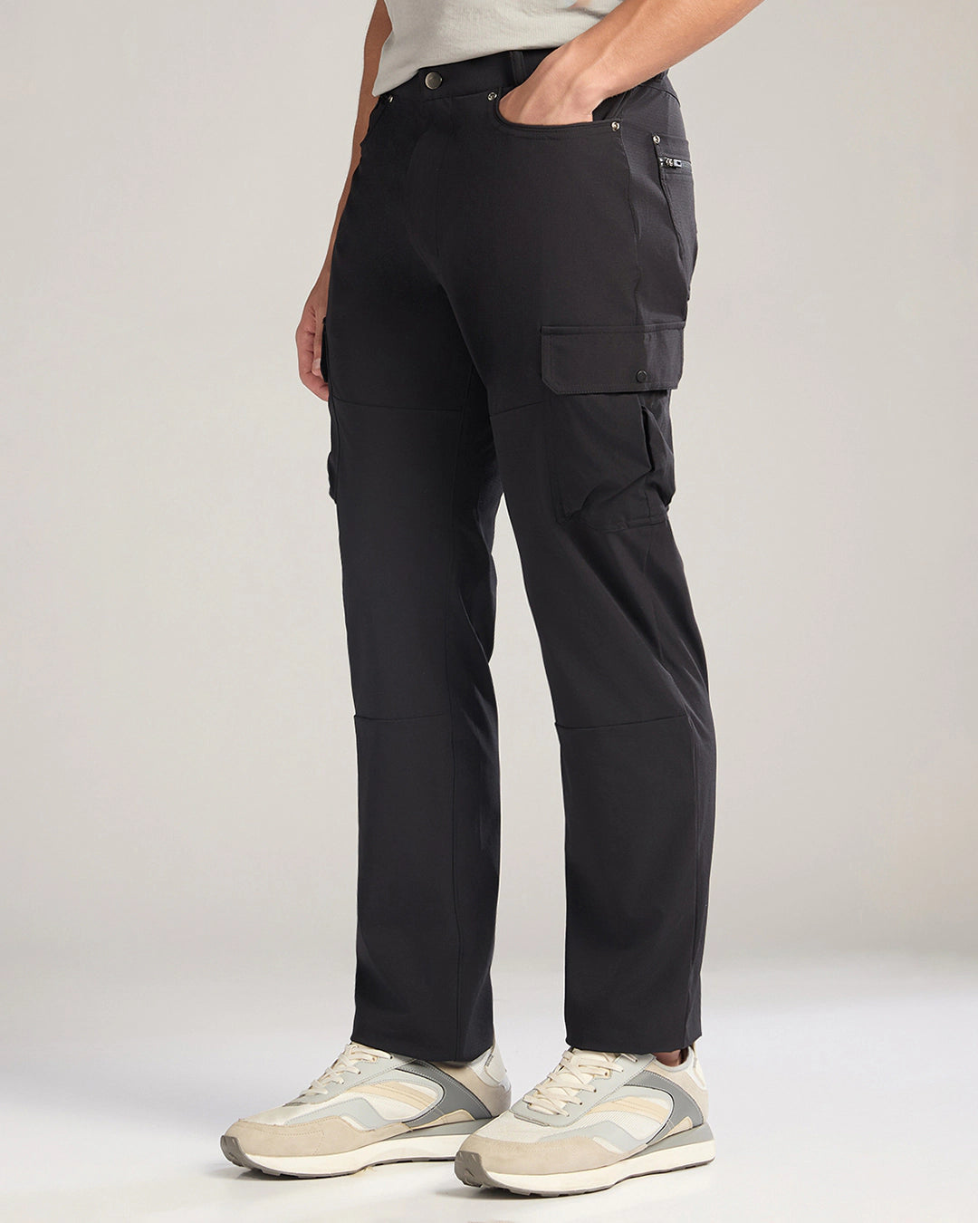 Person wearing black cargo pants on a plain background