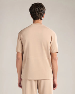 Person wearing a beige outfit on a plain background