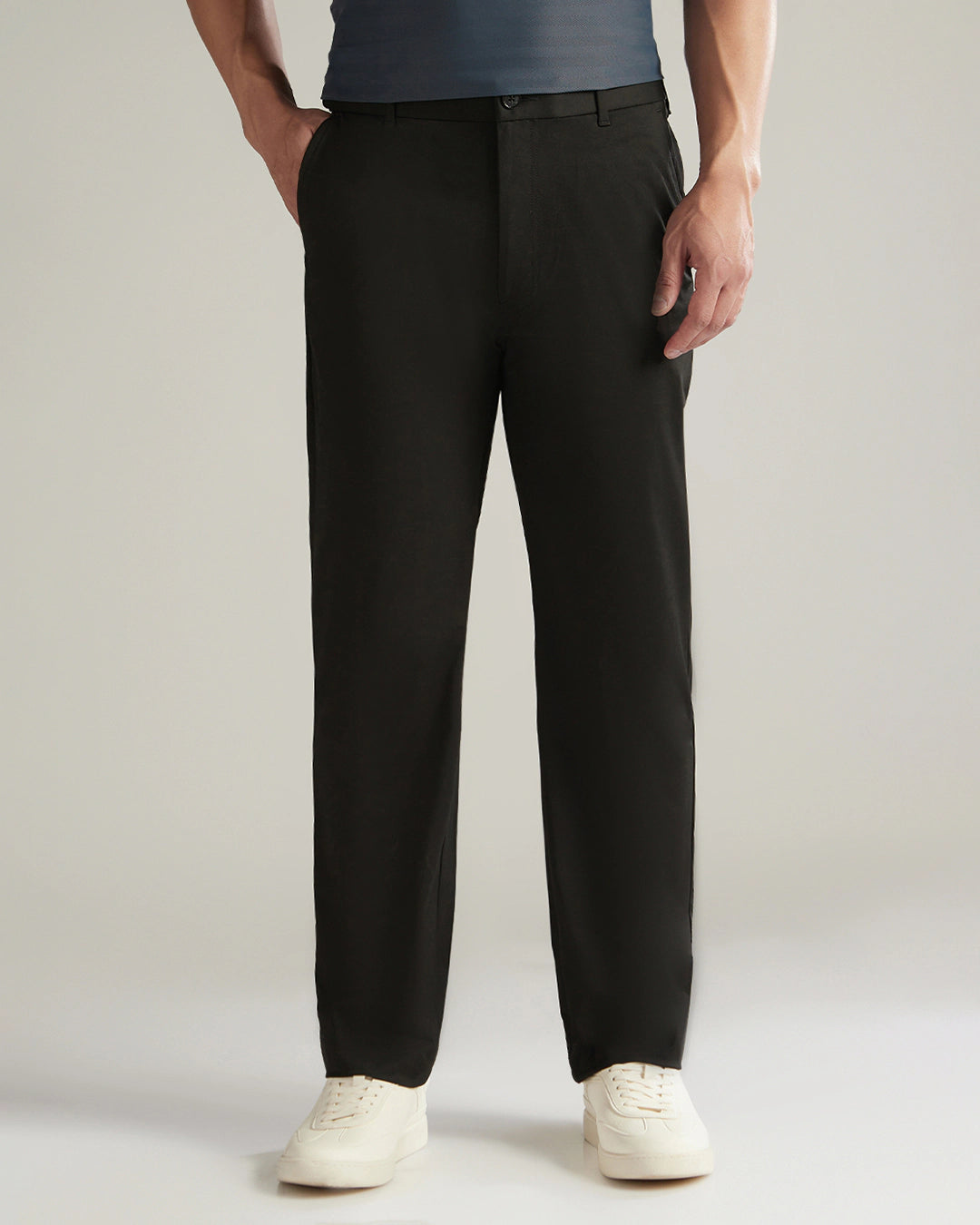 Person wearing black dress pants with a plain background