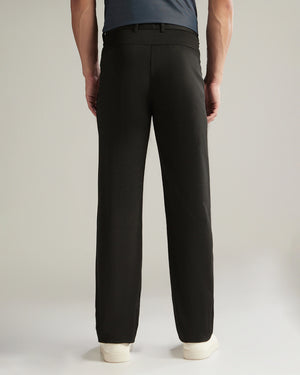Person wearing black pants on a plain background
