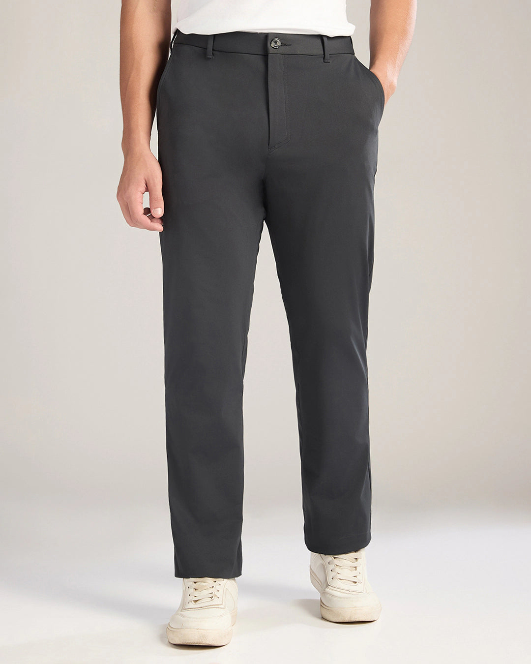 Person wearing dark gray pants on a plain background