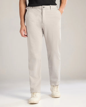 Person wearing beige pants with a plain background