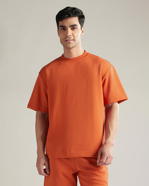 Man wearing an orange outfit against a plain background