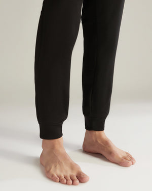 Black sweatpants worn by a person on a plain background