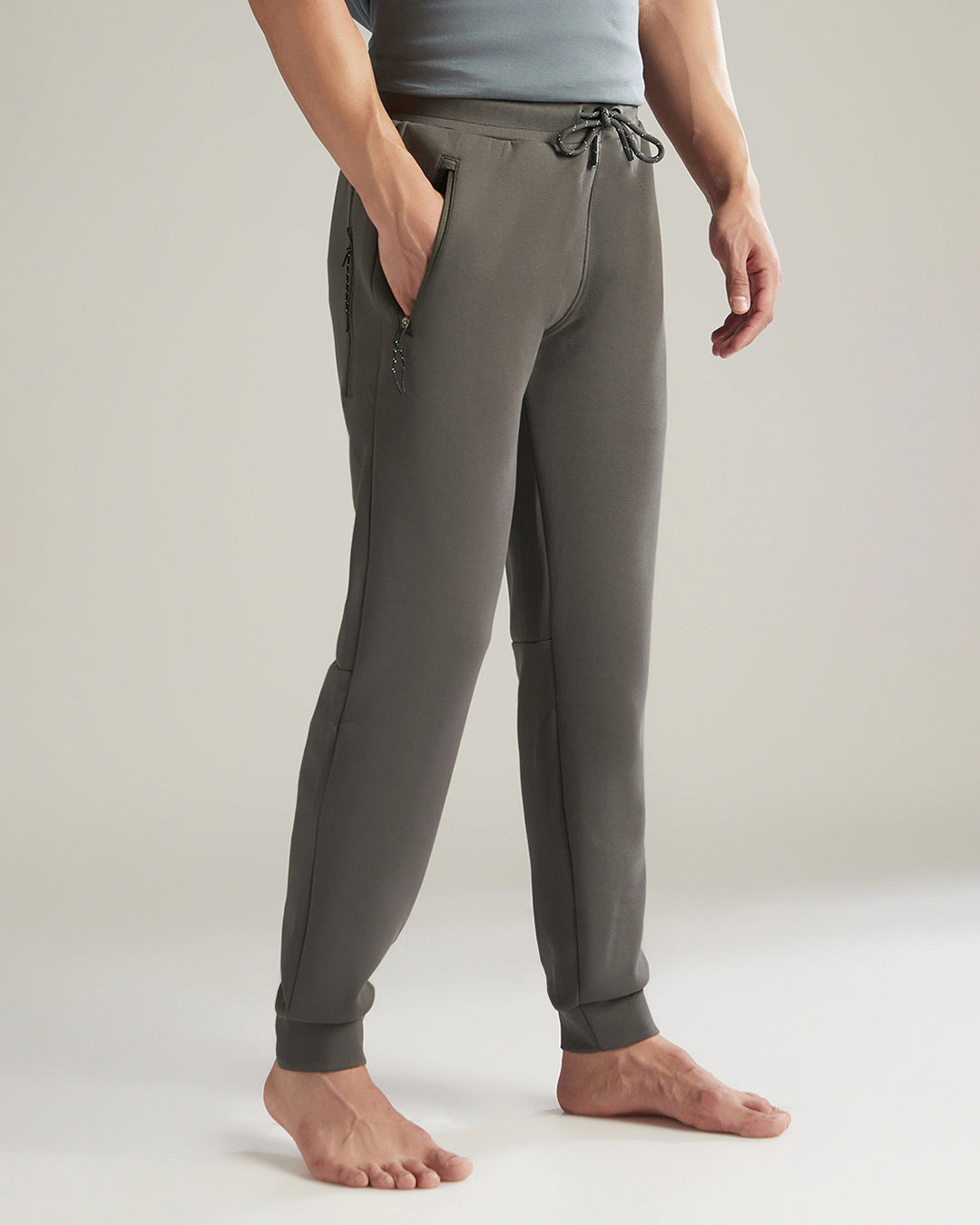 Person wearing gray jogger pants on a plain background