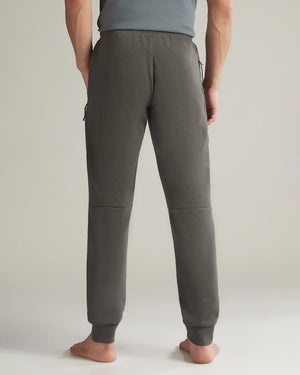 Person wearing gray jogger pants on a plain background
