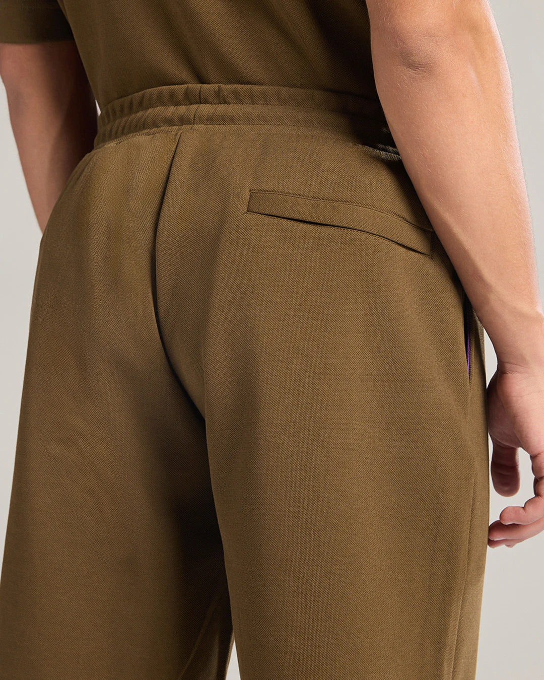 Brown pants worn by a person on a plain background