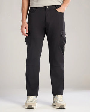 Person wearing black cargo pants on a plain background