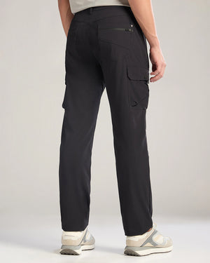 Person wearing black cargo pants on a plain background