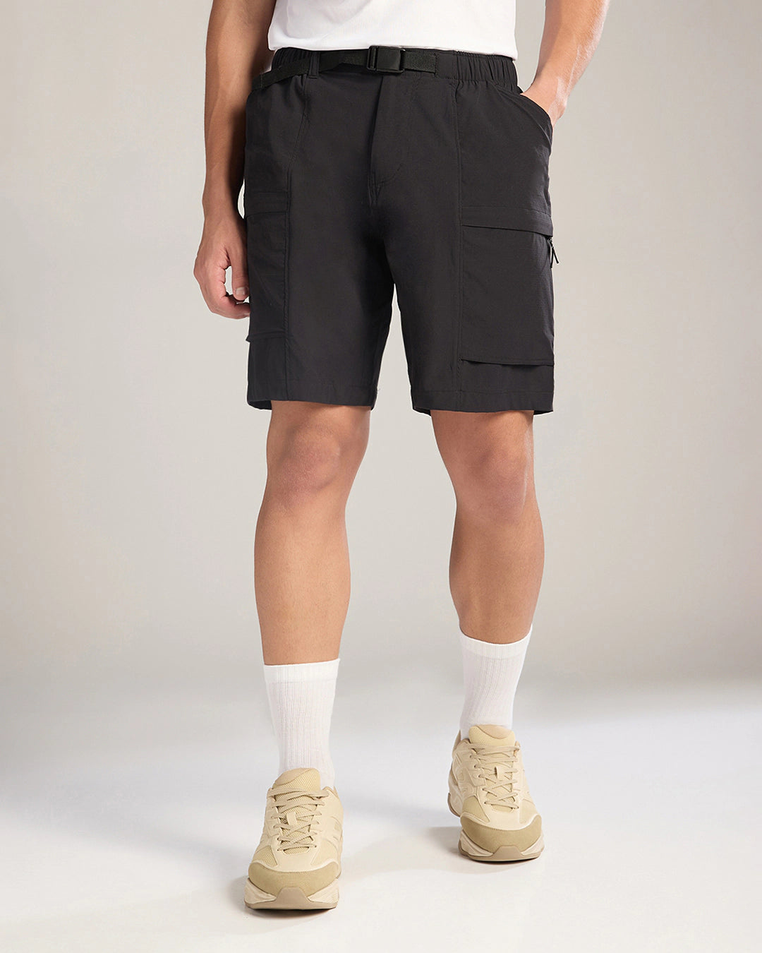 Person wearing black cargo shorts on a plain background