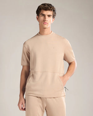 Man wearing a beige outfit against a plain background