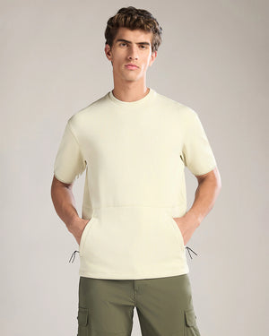 Man wearing a light-colored short-sleeve shirt and green cargo pants on a plain background