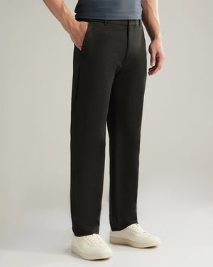 Person wearing black pants and white shoes on a plain background