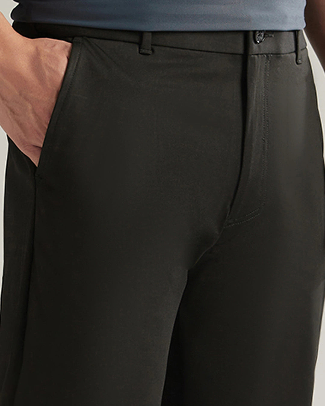 Black pants worn by a person on a light gray background