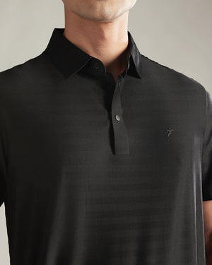 Black polo shirt with a brand logo on a neutral background
