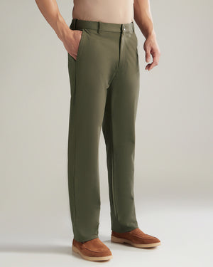 Person wearing olive green pants with a plain background
