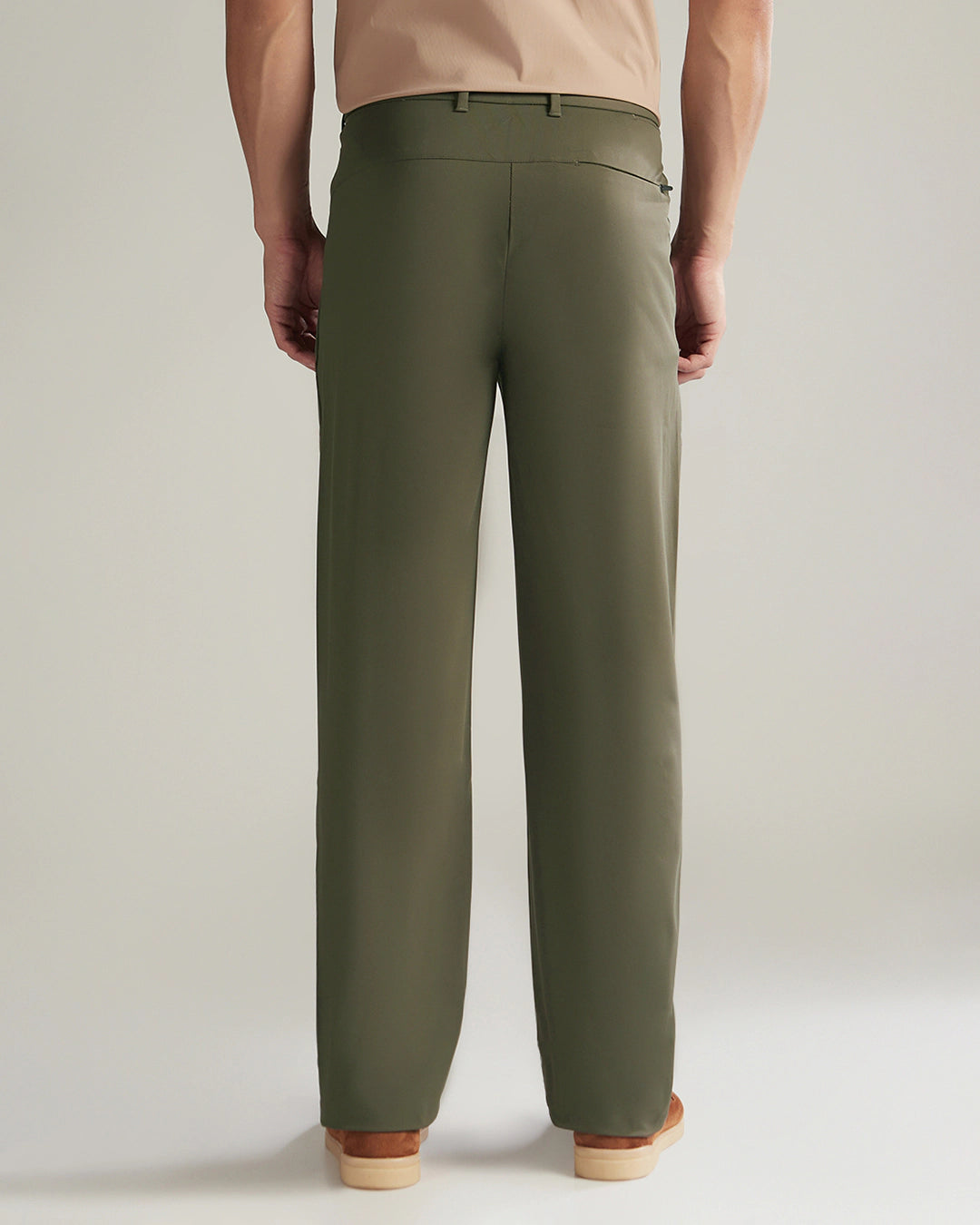 Person wearing olive green pants on a plain background