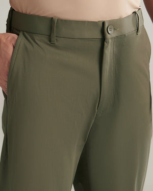 Close-up of olive green pants with a button on a neutral background