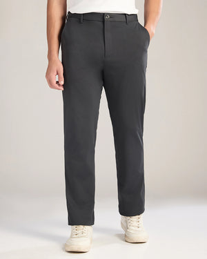 Person wearing dark gray pants on a plain background