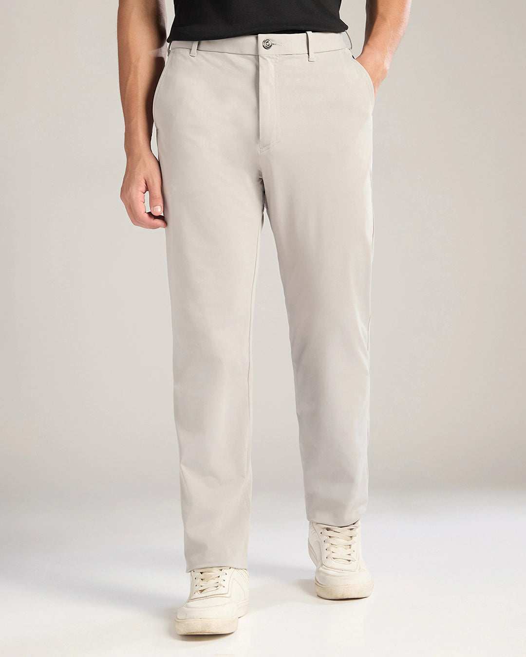 Person wearing beige pants with a plain background