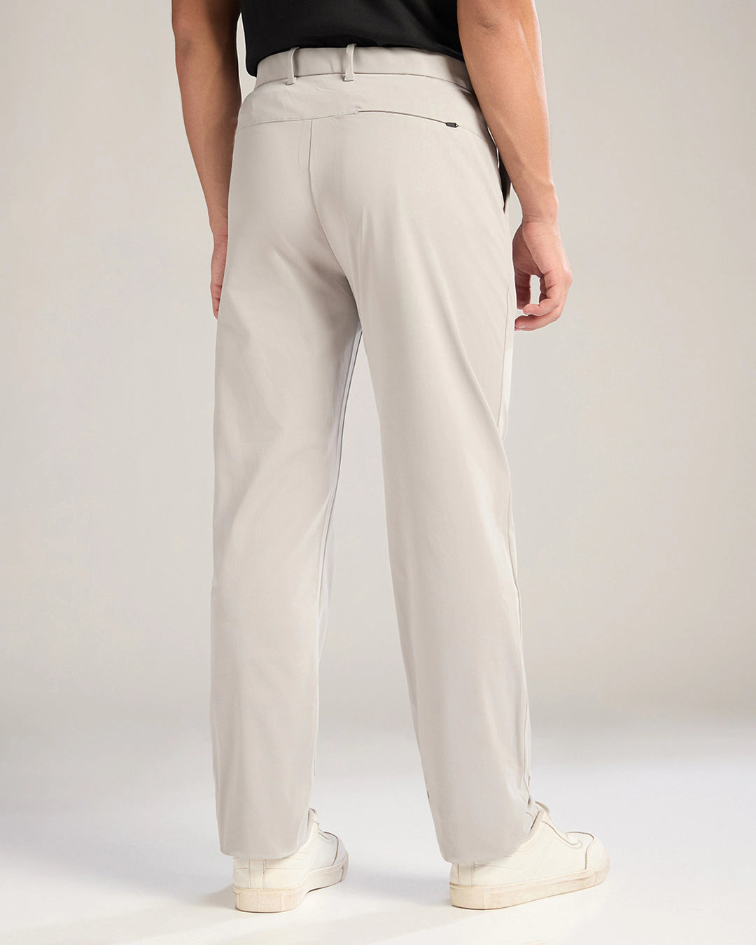 Person wearing beige pants on a plain background