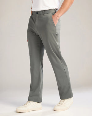 Person wearing gray pants and white sneakers on a plain background