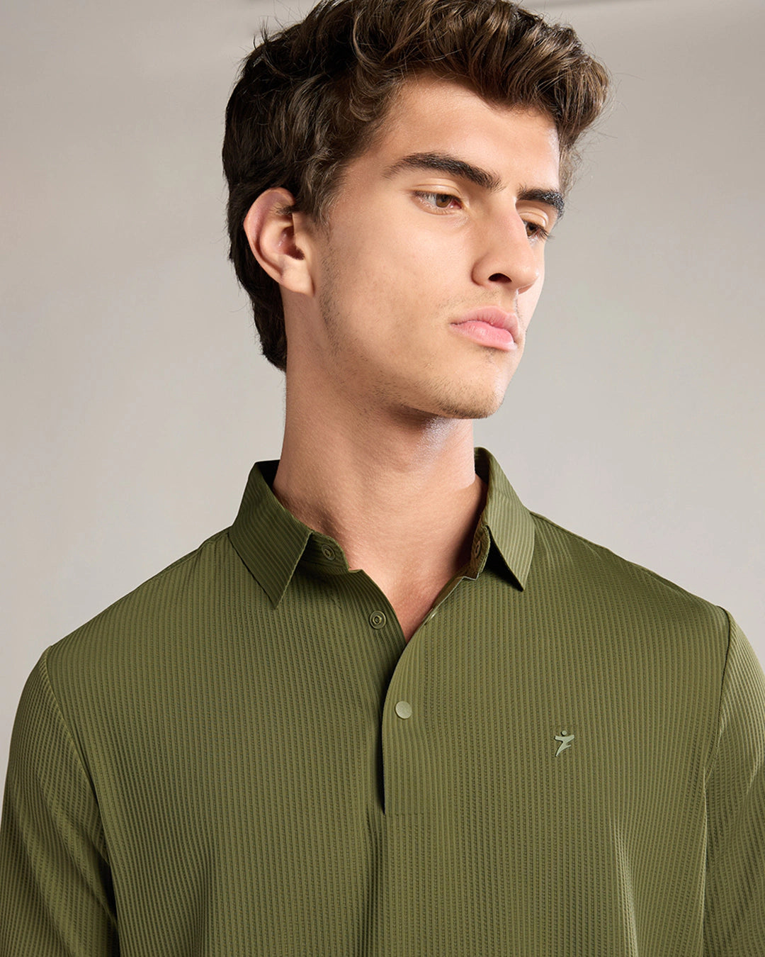 Man wearing a green shirt against a neutral background
