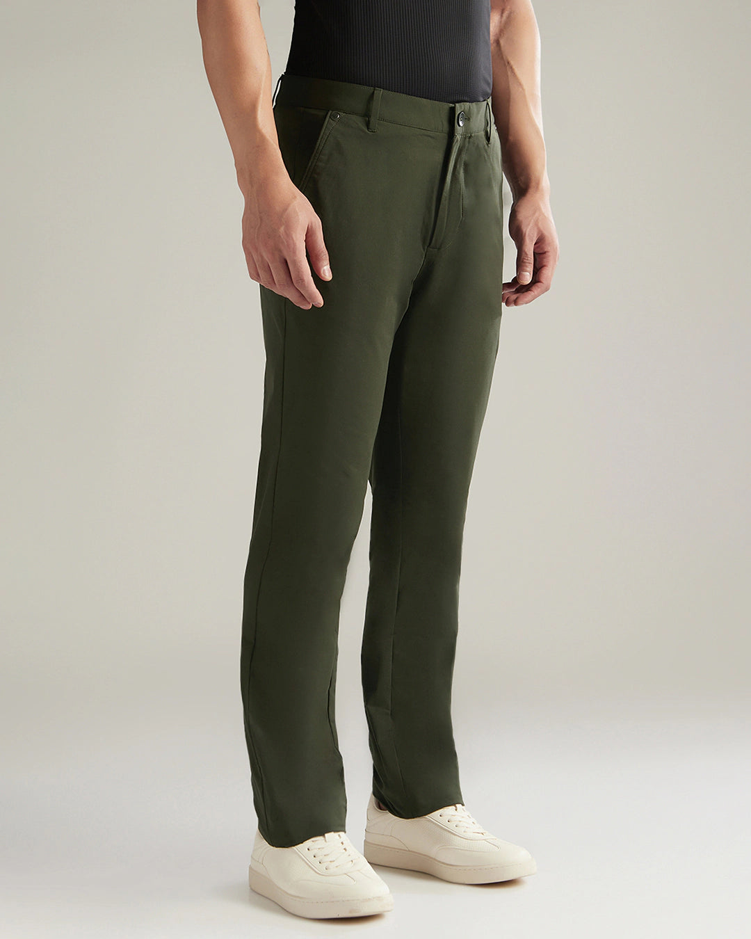 Person wearing green pants on a plain background