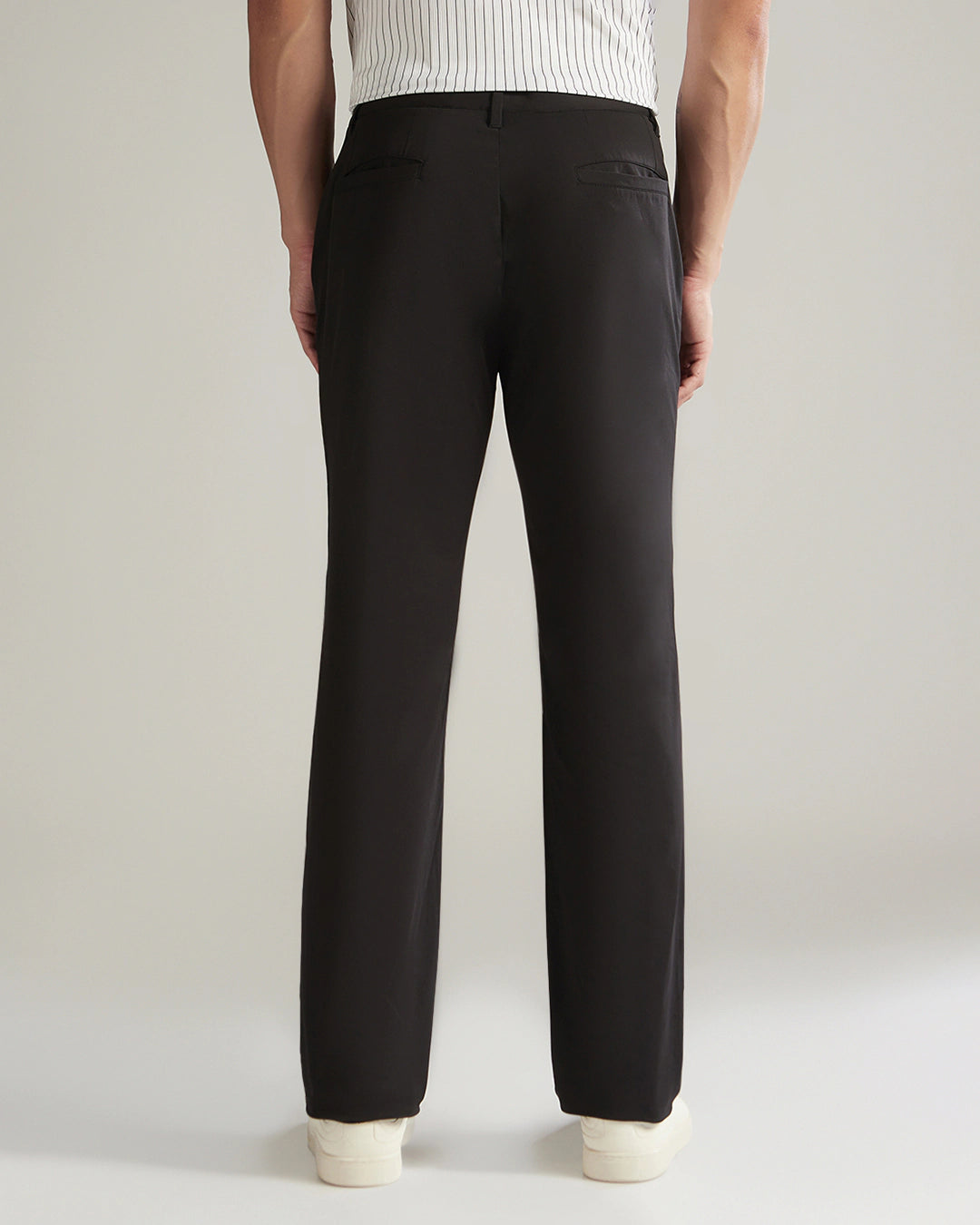 Black pants worn by a person on a plain background