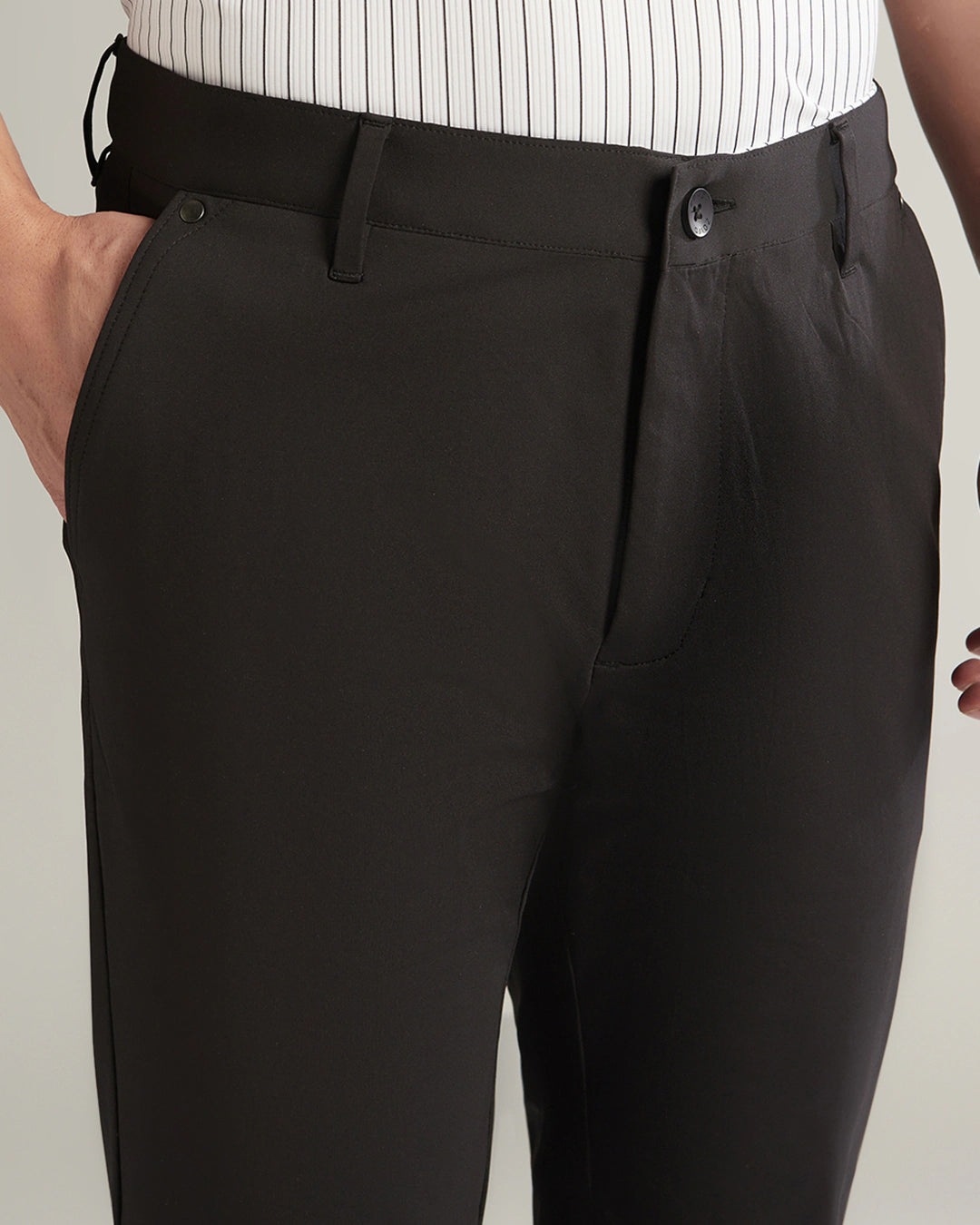 Black pants worn by a person on a plain background