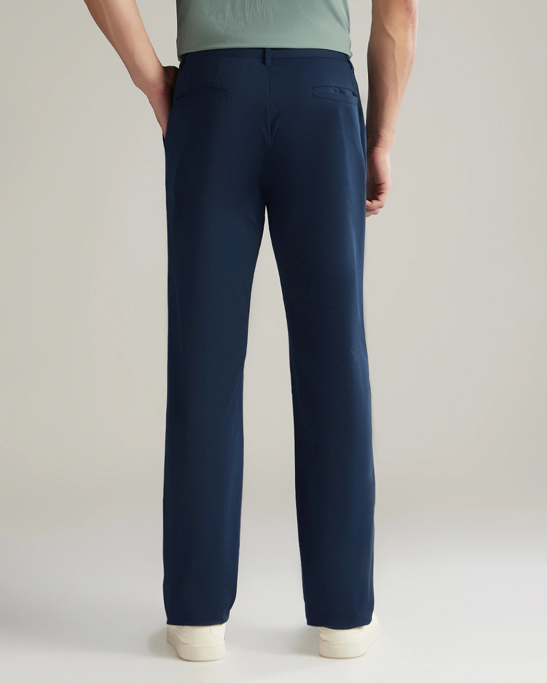 Navy blue pants worn by a person on a plain background