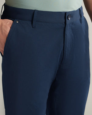 Navy blue pants worn by a person on a plain background